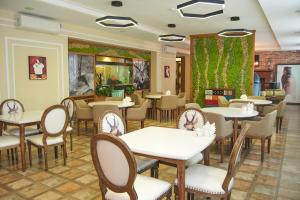 a restaurant with tables and chairs in a room at GREEN Which Hotel in Petropavlovsk