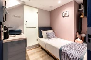 a small bedroom with a bed and a kitchen at Heritage Collection on Arab - A Digital Hotel in Singapore