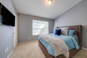 a bedroom with a bed and a flat screen tv at The Lux At Lake Mary in Lake Mary