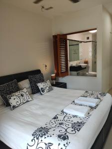 a bedroom with a large white bed with a mirror at Beachfront Beauty! in Mission Beach +14 photos