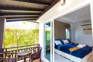 ein Schlafzimmer mit einem Balkon mit einem Bett und einem Tisch in der Unterkunft Nature Line Resort in Khanom + 37 Fotos