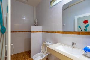 ein Badezimmer mit Waschbecken, Toilette und Spiegel in der Unterkunft Nature Line Resort in Khanom