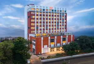 een hoog rood en wit gebouw met veel ramen bij Welcomhotel By ITC Hotels, Guntur in Guntūr