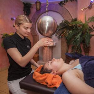 a woman giving a man a head massage at Landhotel Grimmeblick in Winterberg