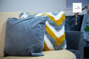 uma almofada sentada num sofá com um cobertor em 5Blythe House Apartments Brierley Hill em Birmingham