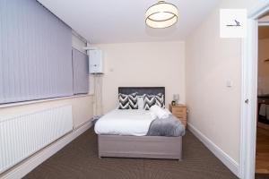 um pequeno quarto com uma cama e uma janela em 5Blythe House Apartments Brierley Hill em Birmingham