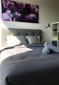 a bedroom with a bed with a purple painting on the wall at KL Sentral, EST Bangsar by SkyLimit Suites in Kuala Lumpur