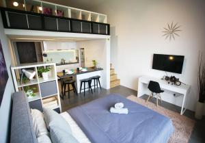 salon z niebieskim łóżkiem i kuchnią w obiekcie KL Sentral, EST Bangsar by SkyLimit Suites w Kuala Lumpur