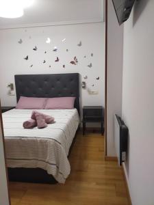 a bedroom with a bed with pink pillows on it at Estudio tipo Loft en el centro de Mugardos in Mugardos
