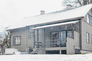 a house with snow on the front of it at Farm hostel - The house in Elektrėnai