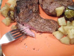 un morceau de steak et de pommes de terre sur une plaque à fourchette dans l'établissement Room in BB - Abbondanza The Farm House, à Alberobello