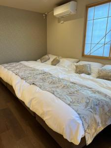 名古屋市にあるIxyz別邸 月夜見の宿の窓付きの客室で、白い大型ベッド1台が備わります。