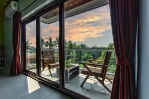 een kamer met een groot raam met een tafel en stoelen bij Om Shanti Residence in Canacona