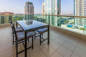 a table and chairs on a balcony with a view of the city at Sea View Studio 10min from beach Royal Oceanic in Dubai