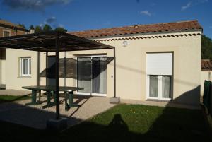 un tavolo da picnic di fronte a una casa di Gite La Dolce Vita a Les Ollières-sur-Eyrieux