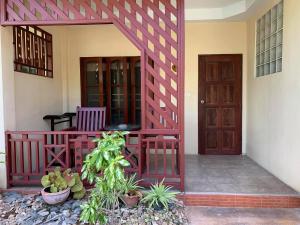 un porche delantero de una casa con puerta de madera en Rattana Guesthouse & Bungalow en Chaweng Beach