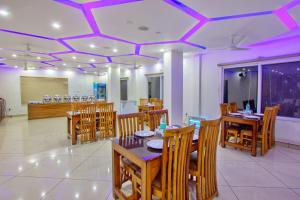 un restaurant avec des tables et des chaises en bois et des plafonds violets dans l'établissement LA Riqueza Bliss Valley Mall Road - Beautiful View of Mountains, à Dharamshala