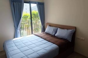 Schlafzimmer mit einem Bett und einem Fenster mit einem Balkon in der Unterkunft Lacasita Huahin in Hua Hin