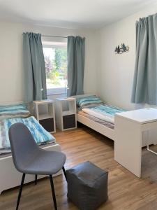 um quarto com 2 camas, uma cadeira e uma secretária em Bauernhof Hopp em Vadersdorf