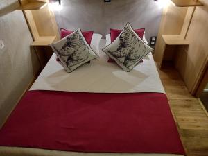 a large bed with two pillows on top of it at Green Hôtels Orléans Nord-Saran in Saran