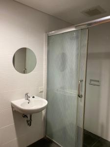 y baño con ducha, lavabo y espejo. en MG Suites 1 Bedroom Apartment Sea View Semarang (KUMU SUITES) en Semarang