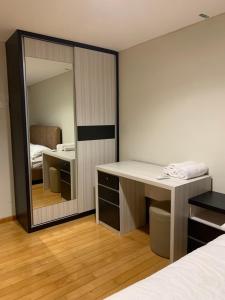 Schlafzimmer mit einem Spiegel, einem Schreibtisch und einem Bett in der Unterkunft MG Suites 1 Bedroom Apartment Sea View Semarang (KUMU SUITES) in Semarang