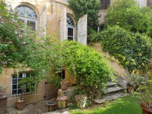 an old house with potted plants on the side of it at Bed and Breakfast Jardin de Marie in Aix-en-Provence +14 photos
