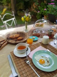 a table with a plate of eggs and a cup of tea at Bed and Breakfast Jardin de Marie in Aix-en-Provence