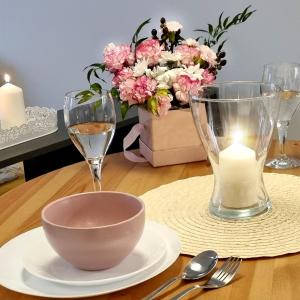 stół z miską, świecą i kwiatami w obiekcie Apple Apartments - Wróblewskiego PRYWATNE MIEJSCE PARKINGOWE w Łodzi