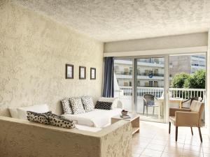 een woonkamer met een witte bank en een balkon bij The Apartments by Esperia in Rhodos-stad