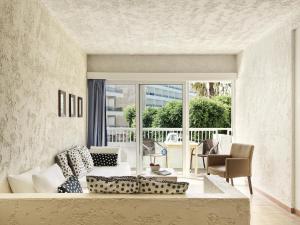 a living room with a couch and a large window at The Apartments by Esperia in Rhodes Town