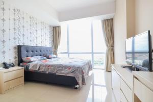 een slaapkamer met een bed en een groot raam bij U Residence 2 by Ana Room in Tangerang