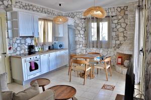 eine Küche und ein Esszimmer mit einem Tisch und Stühlen in der Unterkunft Stone Villa Kefaloniaprivatevillas in Trapezaki