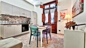 a kitchen with a table and chairs in a room at Zanzi 's Apartments in Avola