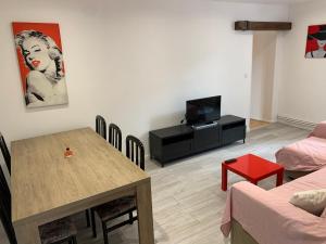 een woonkamer met een eettafel en een televisie bij Appartement le Marilyn in La Tour-du-Pin