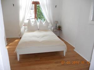 una camera da letto con un letto bianco con cuscini bianchi di Gästehaus La Dolce Vita a Brema