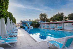 a swimming pool with chairs and a slide at Armas Beach in Kemer