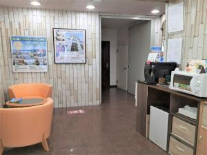 une salle d'attente avec une chaise et un four micro-ondes dans l'établissement Monthly Mansion Tokyo West 21 - Vacation STAY 10868, à Fuchu