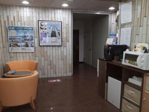 uma sala de espera com uma cadeira e um micro-ondas em Monthly Mansion Tokyo West 21 - Vacation STAY 10861 em Fuchu
