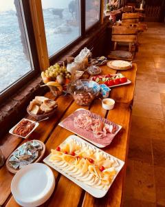 una mesa de madera con un montón de comida. en La Popasul Cerbului en Semenic