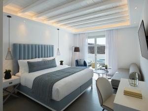 a bedroom with a king sized bed and a living room at Epic Blue Mykonos in Houlakia