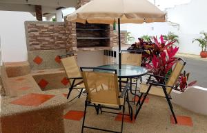 uma mesa e cadeiras com um guarda-sol num pátio em Riveri Salinas V53 em Salinas