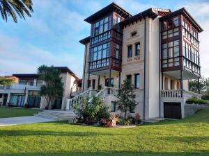 a large house with large windows at Hotel Indiana Llanes in Llanes