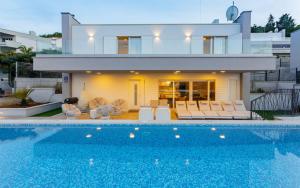 a house with a swimming pool in front of a house at Luxury Blue Villas Vis in Vis