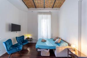 a room with a bed and two blue chairs at Domus Aurea B&B and Suites in Rome