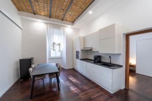 a kitchen with white cabinets and a table with chairs at Domus Aurea B&B and Suites in Rome