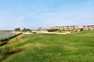 a view of a resort with a green field and the ocean at Ramada Plaza by Wyndham Thraki in Alexandroupoli