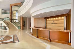 a lobby with a staircase in a building at Ramada Plaza by Wyndham Thraki in Alexandroupoli