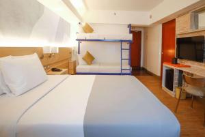a hotel room with a large bed and a tv at TRYP by Wyndham Mall of Asia Manila in Manila