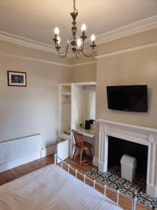 a living room with a fireplace and a flat screen tv at Norfolk Guest House in Bristol